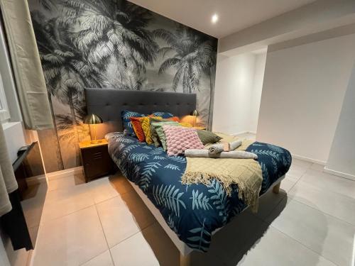 um quarto com uma cama com papel de parede tropical em L'Elégant T2 - Calme et Spacieux em Lens