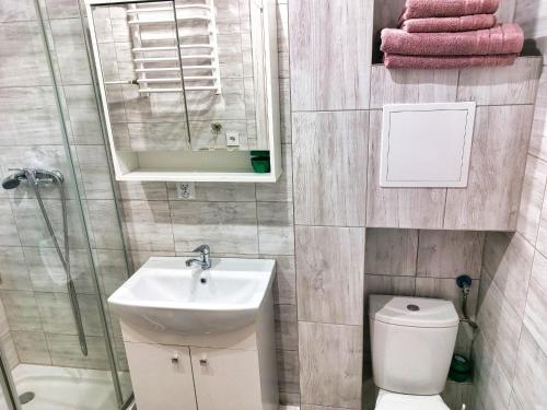 a bathroom with a sink and a toilet and a mirror at Pogodne Suwałki Centrum in Suwałki