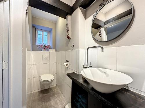 uma casa de banho branca com um lavatório e um espelho em Gite ancienne Imprimerie em Bomal