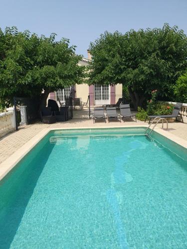 una piscina de agua azul en un patio en Villa Gesinacris avec piscine, en Camaret-sur-Aigues