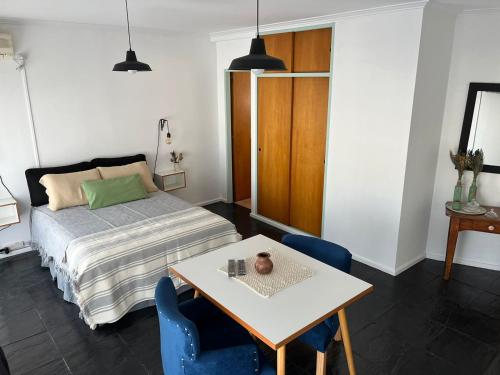1 dormitorio con 1 cama, mesa y sillas en Dpto Pico Alquiler Temporario en Santa Rosa