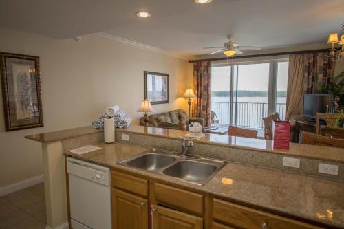 een keuken met een wastafel en een woonkamer bij Blue Heron Beach Resort in Orlando