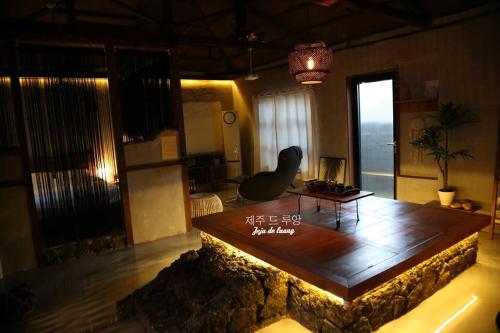 a living room with a table in the middle at Jeju Deluang Gimnyeong 1236 in Jeju