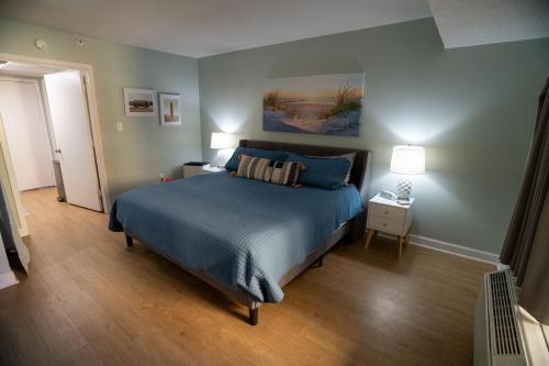 Sunny Seaside Escape Perfect for Couples في ميرتل بيتش: غرفة نوم مع سرير مع لحاف أزرق