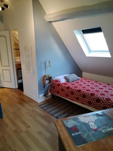 a attic room with a bed and a skylight at Appartement Henri II in Le Mans