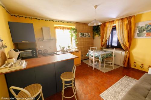 kuchnia z żółtymi ścianami, stołem i krzesłami w obiekcie Casadinonnabella w mieście Biella
