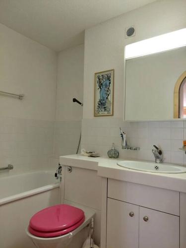 a bathroom with a pink toilet and a sink at Charmante Wohnung im Dorfkern in Klosters