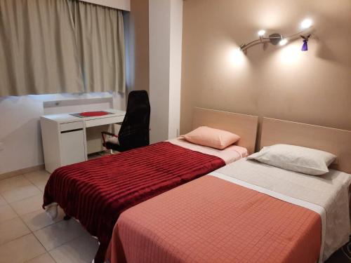 a hotel room with two beds and a desk and a desk at 3 Bedroom Apartment in Nicosia