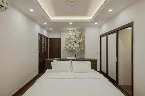 ein Schlafzimmer mit einem großen Bett mit weißer Bettwäsche in der Unterkunft Hanoi Premium 160 Sqm Apt with Top-Quality Furnishing in Hanoi