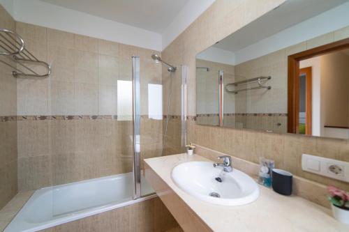 a bathroom with a sink and a shower and a mirror at Villa Ariana Playa Blanca in Playa Blanca