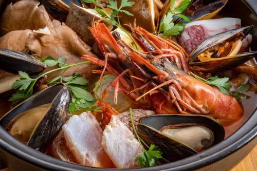 a bowl of food with mussels and other seafood at Setouchi Island Stays Suo Oshima in Suo Oshima