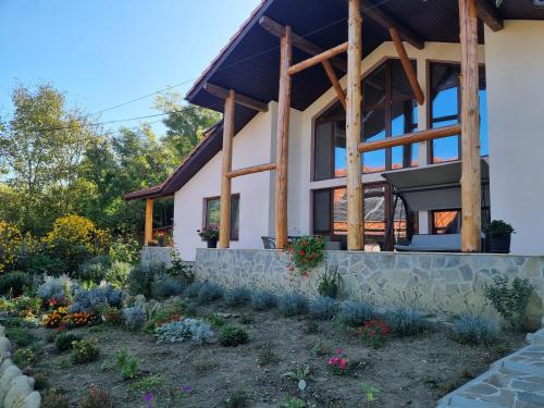 a house with a garden in front of it at Pensiunea Agroturistica Diana in Măgura
