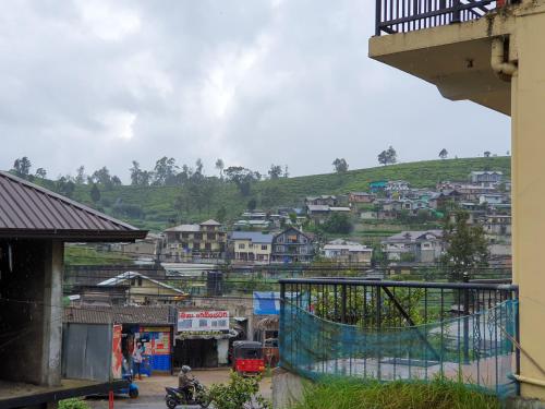 a view of a town with houses on a hill at Ruchi House in Nuwara Eliya