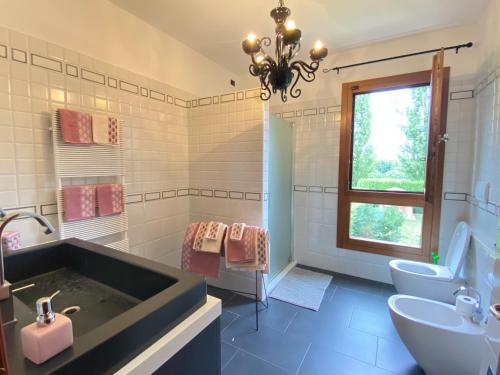 y baño con bañera, aseo y lavamanos. en Villetta Diana Cozy House, en Piazzola sul Brenta