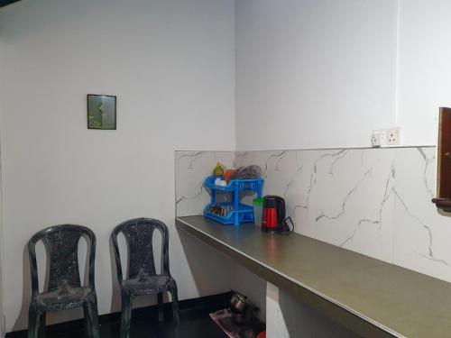 two chairs sitting next to a counter in a room at Ruchi House in Nuwara Eliya
