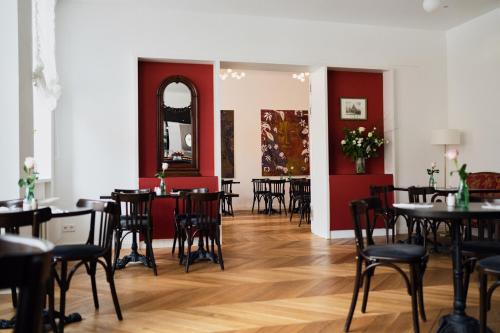 a dining room with tables and chairs and a mirror at Hotel Lindenufer in Berlin