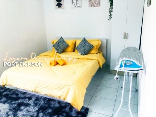 1 dormitorio con cama amarilla y alfombra azul en Laguna Damai Homestay PortDickson - "PoolView & BeachNearby" en Port Dickson