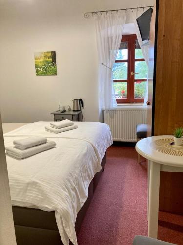 a bedroom with a large white bed with a window at Penzion Moravia - free parking in the city center in Mikulov