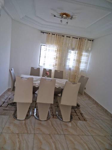 uma sala de jantar com mesa e cadeiras em Residence Les Bourgeois appartementen. em Iaundé