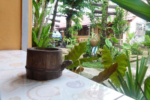 a pot sitting on a table in a garden at Khamphouy Guesthouse in Champasak