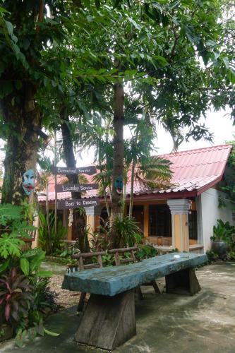 a building with a bench in front of it at Khamphouy Guesthouse in Champasak