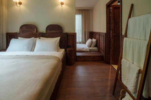 1 dormitorio con 1 cama grande y espejo en Elwood Hotel en Rize