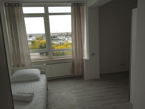 a room with a bed and a large window at Apartament Panorama Kalisz Złota 71 in Kalisz