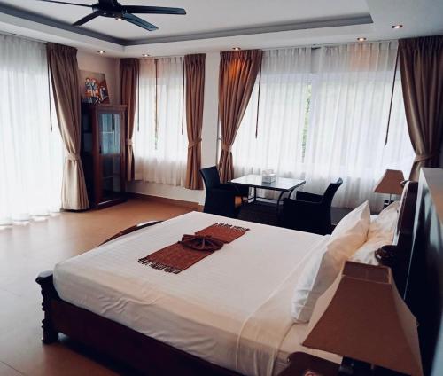 a bedroom with a large bed and a table with chairs at IslandView Villa in Choeng Mon Beach