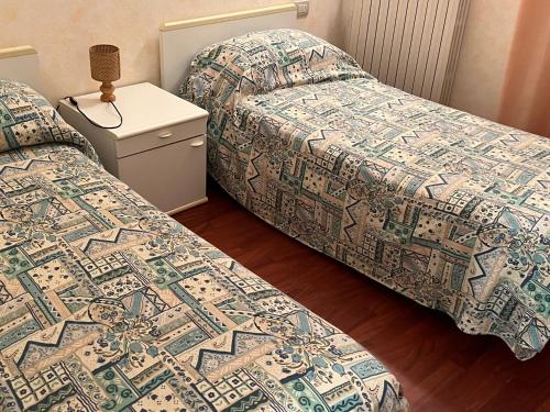 dos camas sentadas una al lado de la otra en una habitación en Savoia Riccione Viale Ceccarini 27, en Riccione