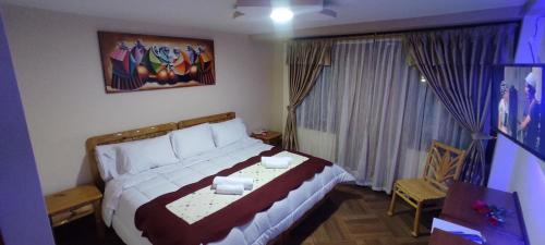 um quarto com uma cama num quarto com uma janela em Hospedaje La Joya em Otavalo