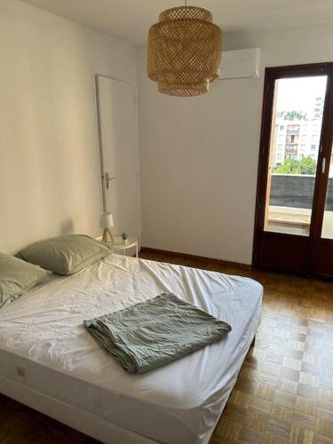 een slaapkamer met een bed met een groene deken erop bij Appartement spacieux bien situé in Marseille