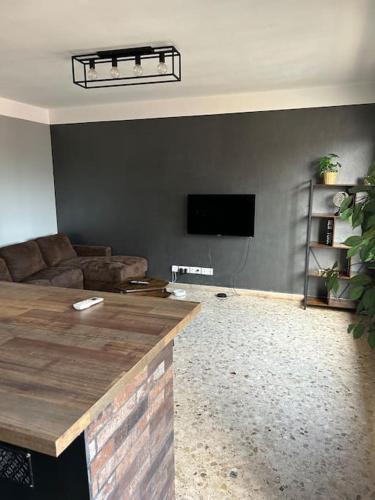 een woonkamer met een bank en een flatscreen-tv bij Appartement spacieux bien situé in Marseille