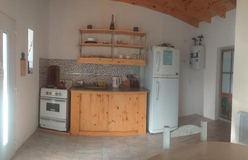een keuken met een witte koelkast en een fornuis bij Bungalows La Nicasia de San Pedro in San Pedro
