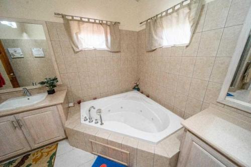 a bathroom with a large tub and a sink at Sweet Home Grenada Caribbean in Lance aux Épines