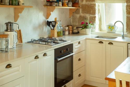 a kitchen with white cabinets and a stove top oven at Masal Evimiz in Antalya