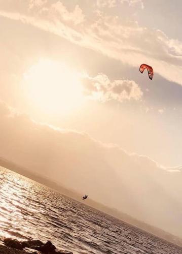 a person is flying a kite on the beach at Beausoleil SPA Villa L-Geneva & Lake & Mountains-Wilena Home, Full Love in Chens-sur-Léman