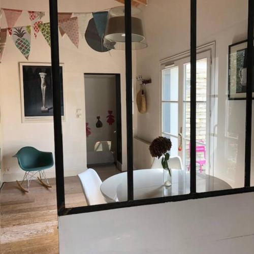 Cette chambre comprend une table, des chaises et un miroir. dans l'établissement Maison vendéenne à 5 min du bord de mer, à Saint-Hilaire-la-Forêt