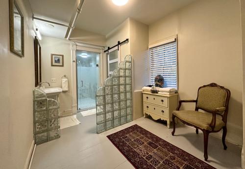 a bathroom with a chair and a sink and a shower at Amethyst Garden in Savannah