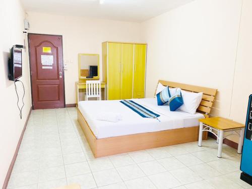 a bedroom with a large bed and a television at Goody Hotel in Bangkok