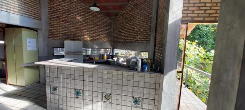 uma cozinha com um balcão com um lavatório em Casa Vitral - Em condomínio fechado - Aldeia/PE em Pau dʼAlho