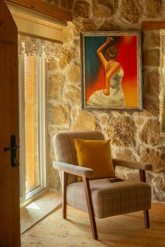 a living room with a chair and a painting on the wall at Masal Evimiz in Antalya