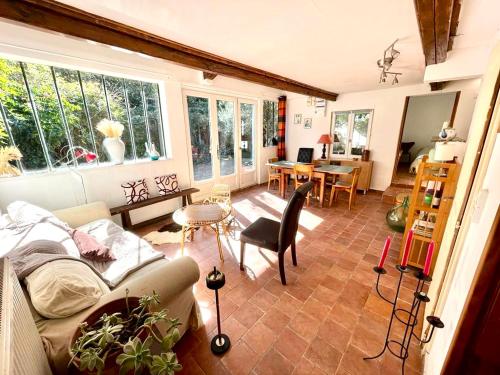 un salon avec un canapé et une table dans l'établissement Charmante maison dans jardin, calme, 55m2- 2ch, métro, très proche Paris, à Vitry-sur-Seine