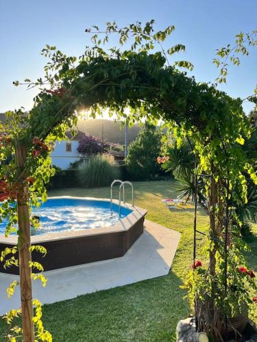 an arch with a pool in a garden at Atlantic Nest Poiares in Vila Nova de Poiares