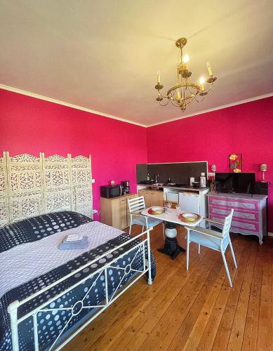 une chambre avec un lit et un mur rose dans l'établissement Domus Lemaitre 6 - parking-Belgique, à Bavay