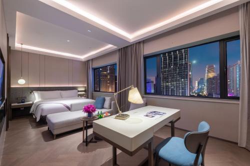 a hotel room with a bed and a desk at Imperial Traders Elong Hotel in Guangzhou