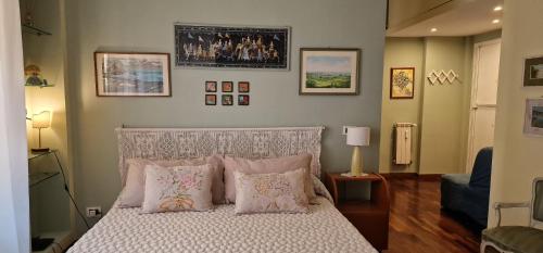 - une chambre dotée d'un lit avec des oreillers et des photos sur le mur dans l'établissement Casa Rosi, à Rome