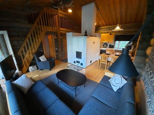 vistas panorámicas a una sala de estar con sofá y mesa en Lumi - kelohirsimökki Rukalla, log cabin at Ruka, en Kuusamo