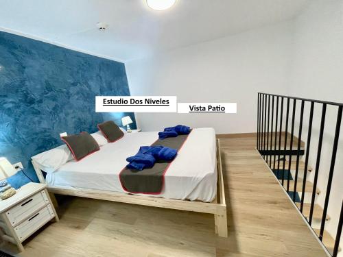 a bedroom with a bed with a blue wall at El Sueño De Alejandra - Apartments in Las Palmas de Gran Canaria