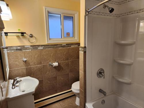 a bathroom with a toilet sink and a shower at Sunparlor Motel in Leamington