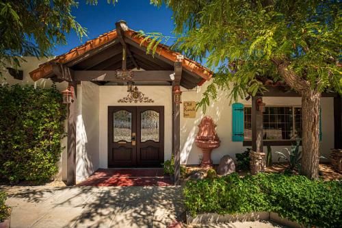 a house with a wooden door and a tree at Old Ranch Inn - Adults Only 21 & Up in Palm Springs